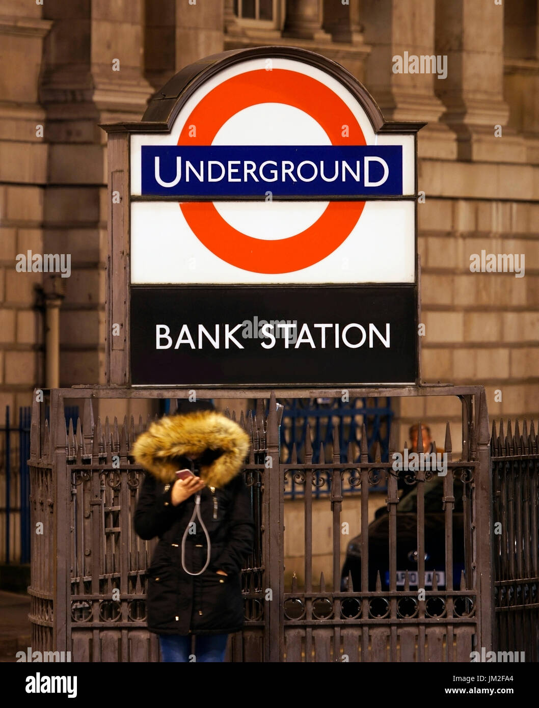 Vista notturna della giunzione della banca, la gente presente guardando il suo telefono cellulare. Il quartiere finanziario, la stazione della metropolitana di Bank presente. Città di Londra. Foto Stock