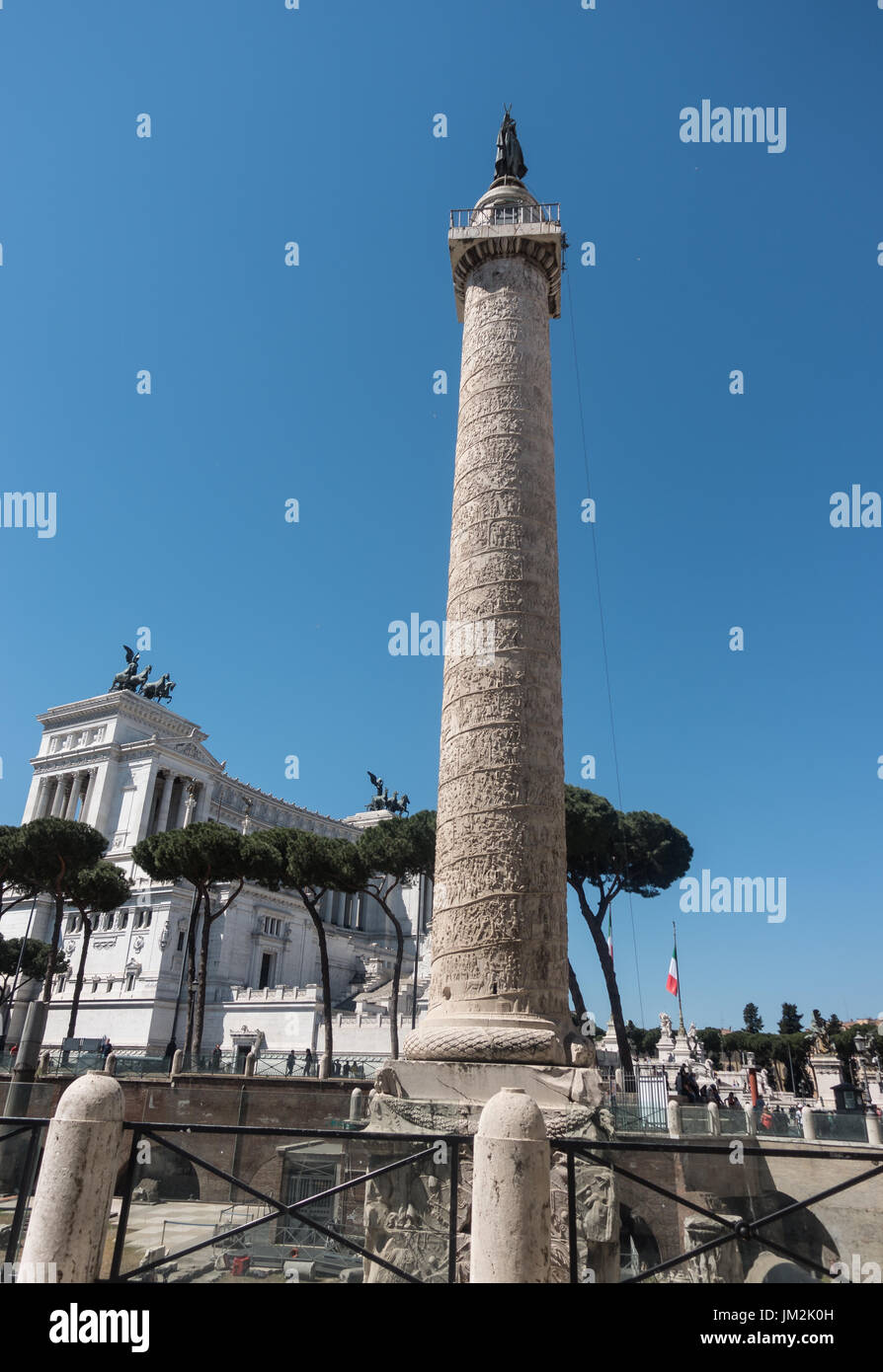Antica Colonna di Traiano con spirale bassorilievo; Victor Emmanuel II in background. San Pietro statua in bronzo sulla sommità, posta dal papa Sisto 5 nel 1587. Foto Stock