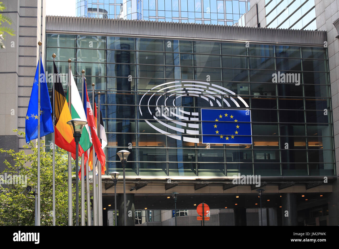 Bruxelles, Belgio - 17 Luglio 2017: Edificio del Parlamento europeo in una giornata di sole. Emblema del Parlamento europeo e nei paesi dell'UE bandiere. Foto Stock