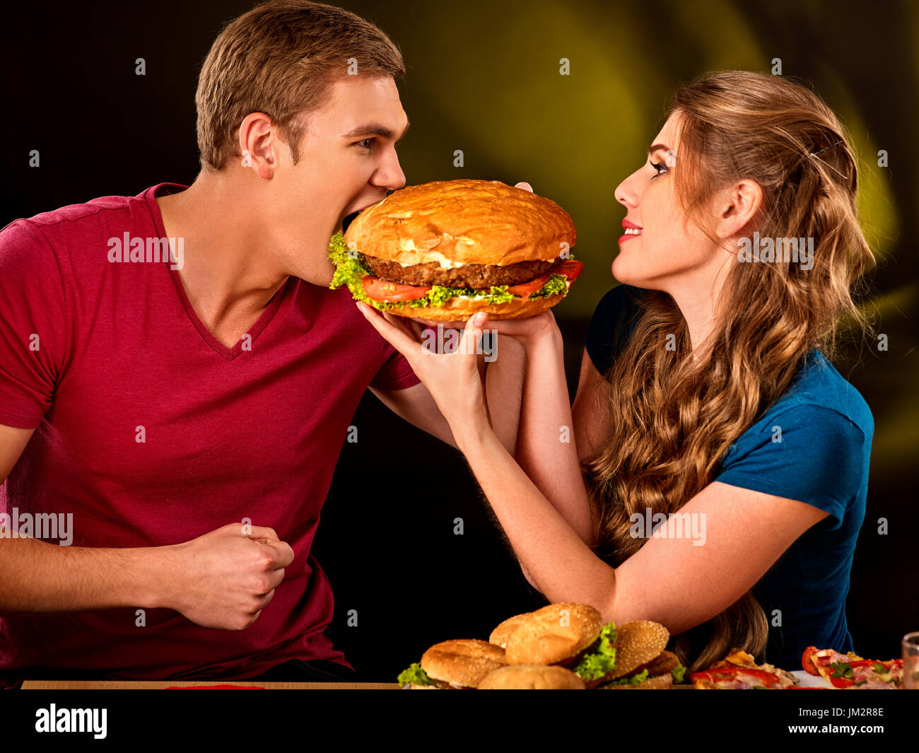 Paio di mangiare fast food. L uomo e la donna il trattamento di hamburger . Foto Stock