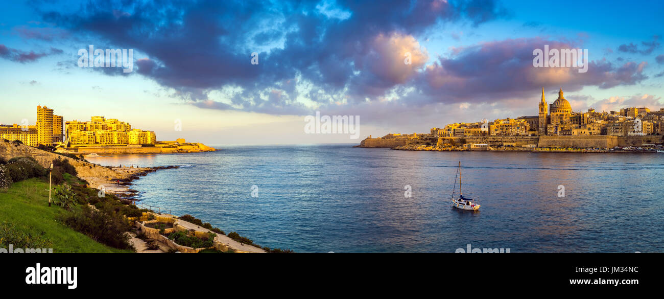 La Valletta, Malta - panoramica vista sullo skyline della città antica di La Valletta e Sliema a sunrise shot da Manoel island in primavera con la vela boa Foto Stock