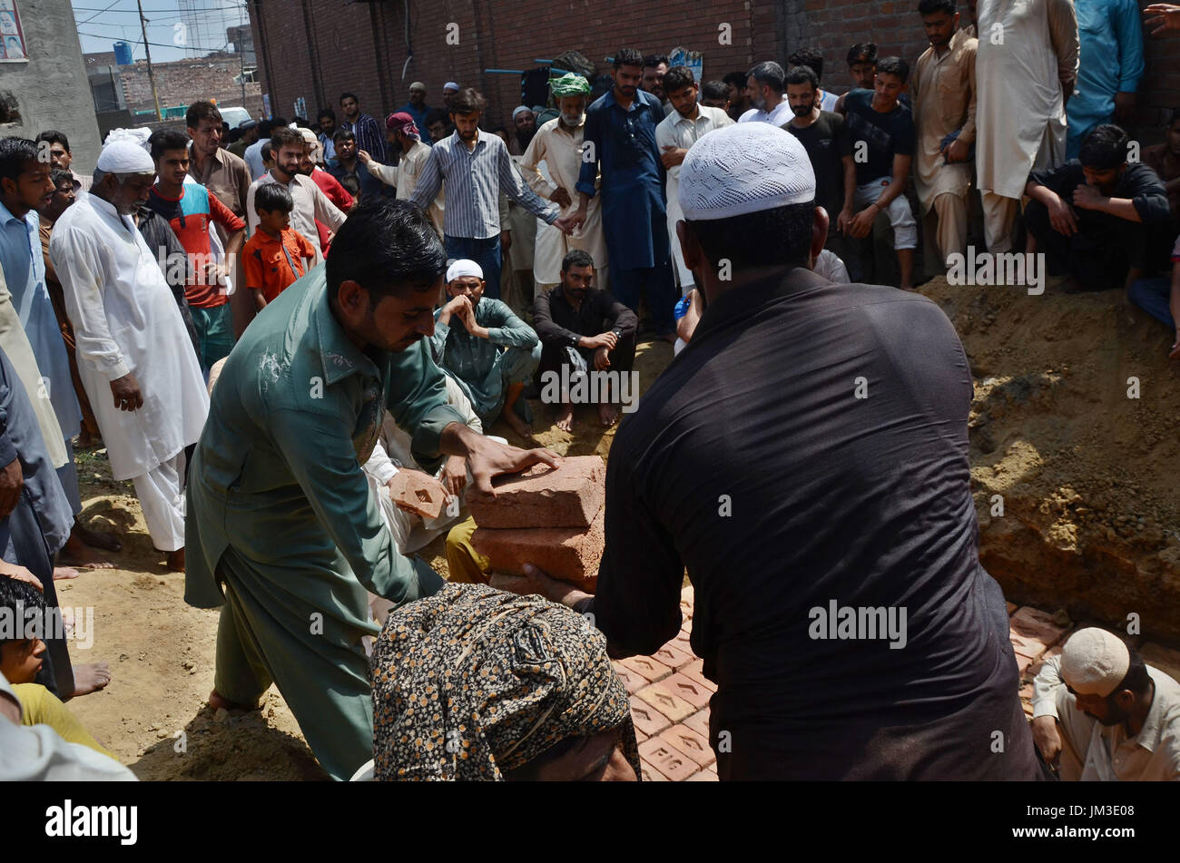 Lahore, Pakistan. 26 Luglio, 2017. Il pakistan parenti delle due vittime blast polizia fratelli Ali Raza e Ghulam Murtaza che subirono il martirio nel suicidio mortale di BLAST su Ferozepur Road vicino al Arfa Karim Tower, piange durante la loro cerimonia di sepoltura di Lahore. Una esplosione rivendicato da Tehreek-e-talebani in Pakistan (TTP) ucciso almeno 29 persone e il ferimento di decine in un affollato mercato ortofrutticolo nella città pakistana di Lahore. Credito: Rana Sajid Hussain/Pacific Press/Alamy Live News Foto Stock