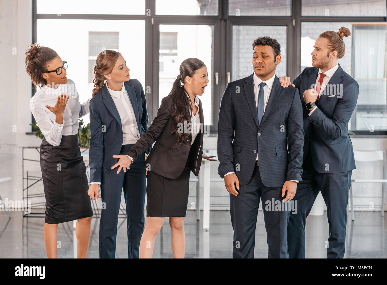 Giovani imprenditori emotiva nel convenzionale litigi in ufficio moderno e multiculturale di team aziendali Foto Stock