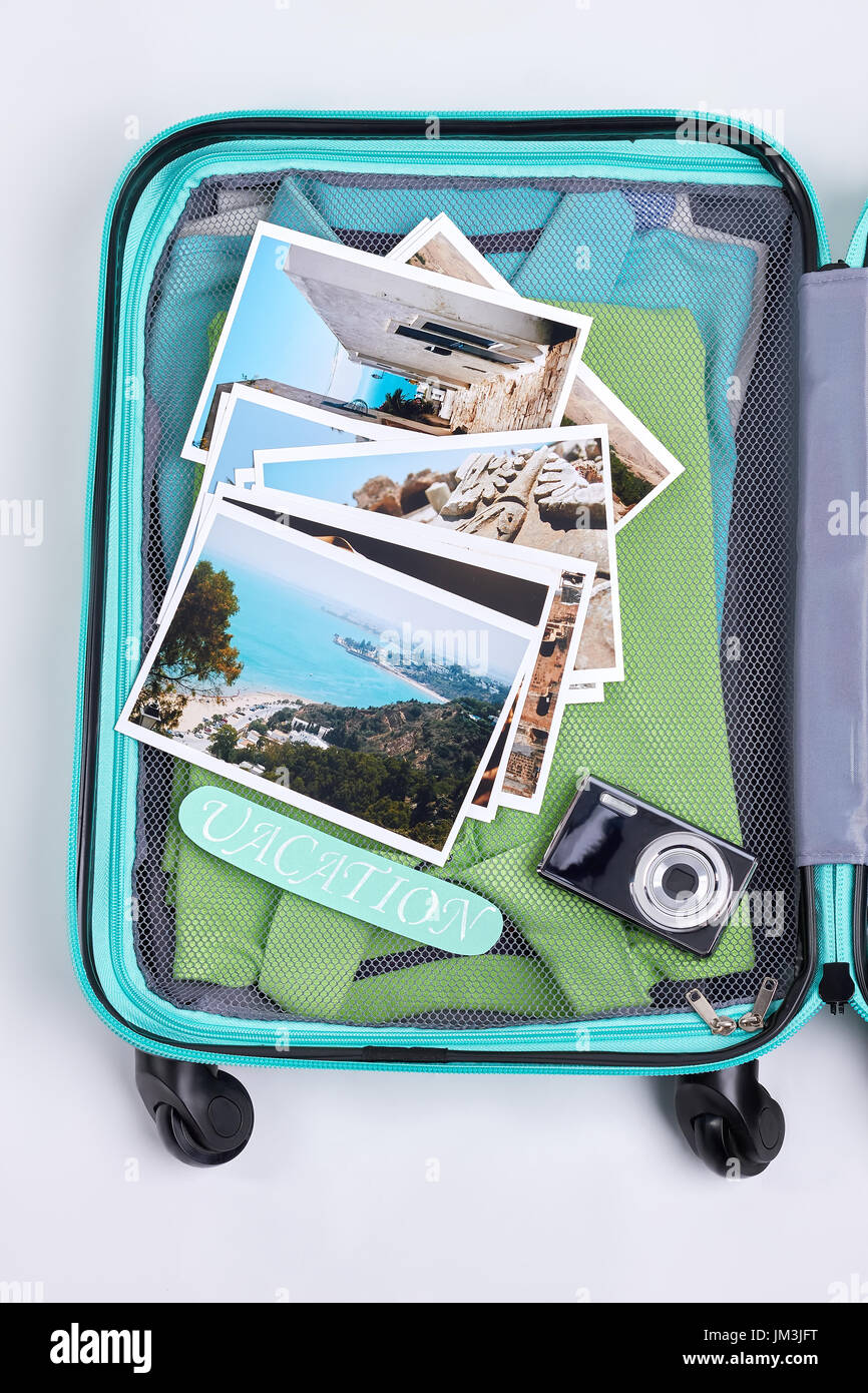 Immagine ritagliata della valigia aperta. Bagagli di viaggiatori con  diverse foto e accessori. Pronto per la vacanza Foto stock - Alamy
