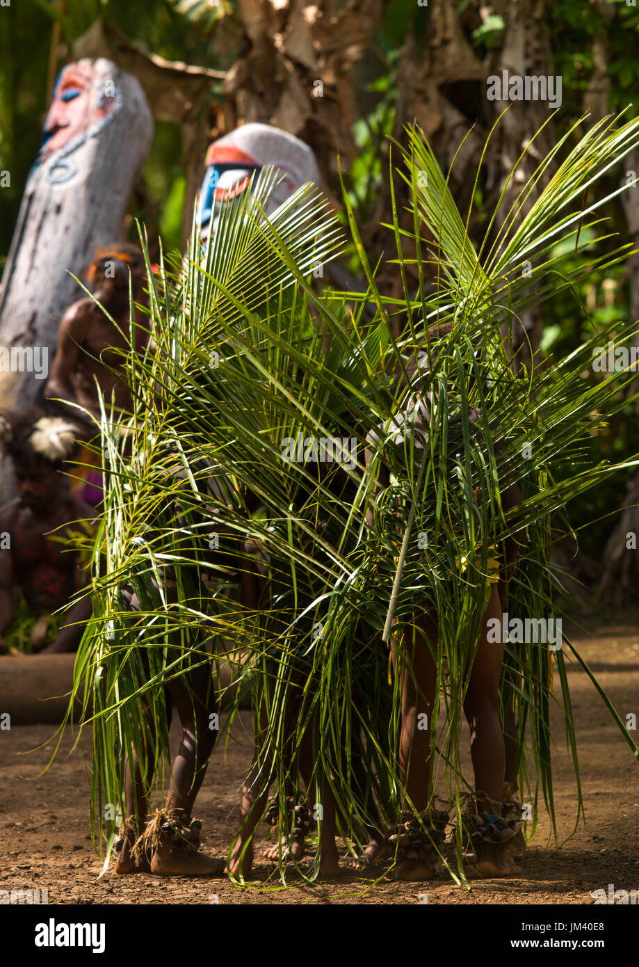 Piccoli bambini Nambas coperto con foglie di palmo ballando nella parte anteriore della fessura tamburi gong durante il palm tree danza, Malekula island, Gortiengser, Vanuatu Foto Stock