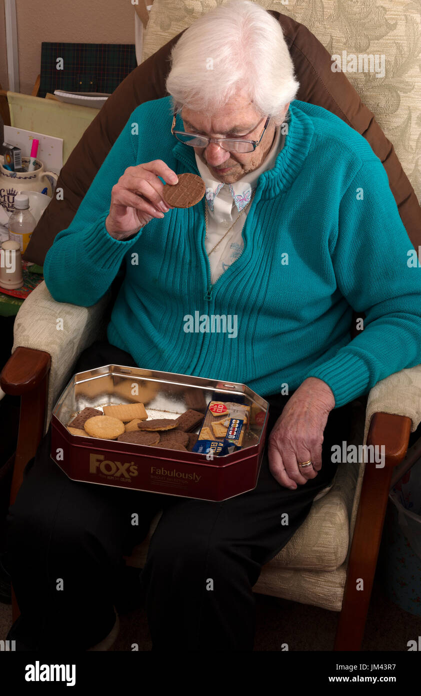 La vecchiaia titolare di pensione o di rendita con una scatola di biscotti Foto Stock