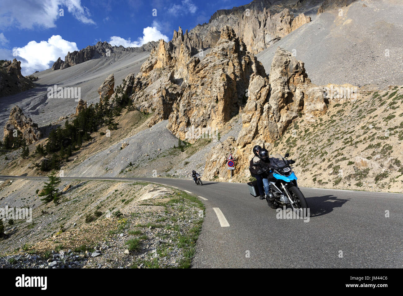 Due motociclette in sella sulla strada attraverso il paesaggio lunare a casse deserte, Col d'Izoard, Francia. Foto Stock