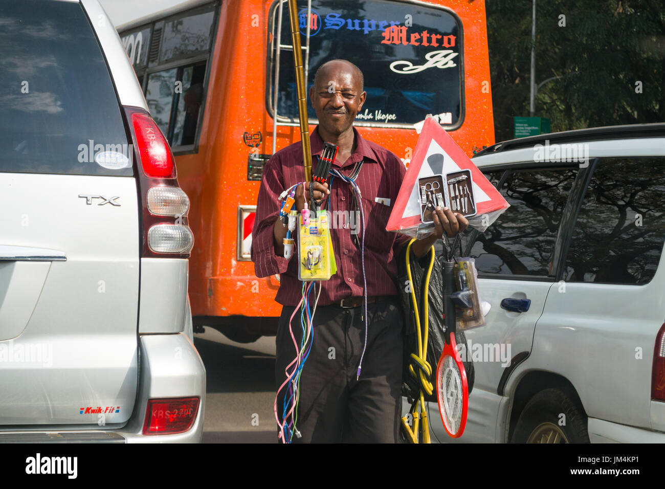 Un uomo che offre prodotti per la vendita ai conducenti bloccati nel traffico su autostrada Uhuru di Nairobi, in Kenya Foto Stock