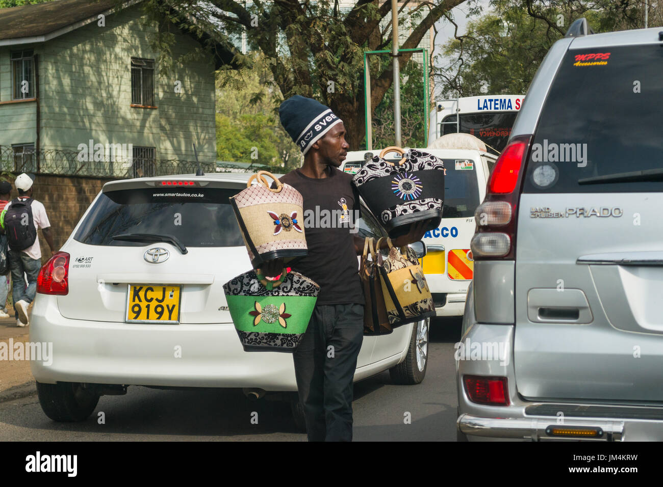 Un uomo che offre borse per la vendita ai conducenti bloccati nel traffico su autostrada Uhuru di Nairobi, in Kenya Foto Stock