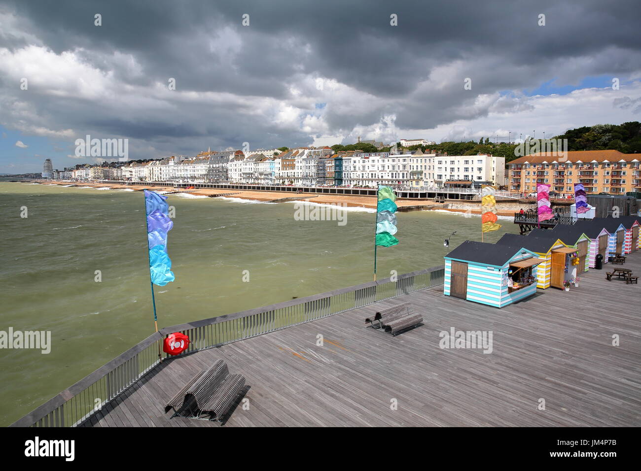 HASTINGS, Regno Unito - Luglio 23, 2017: vista del mare dal molo (ricostruita e aperta al pubblico nel 2016) con capanne colorate in primo piano e un beaut Foto Stock