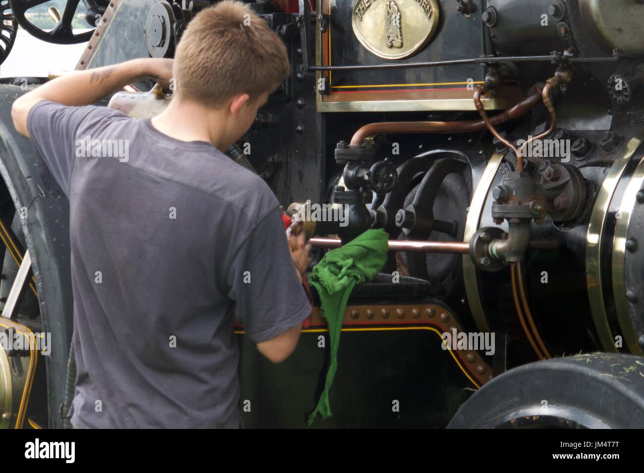 Uomo di effettuare interventi di manutenzione sul motore di trazione a Masham fiera del vapore, Masham, North Yorkshire, Regno Unito Foto Stock
