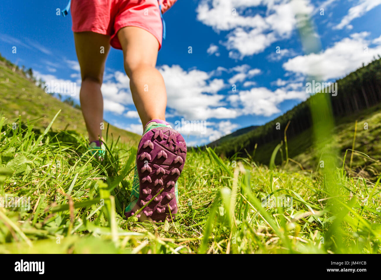 La donna a camminare in montagna in sport scarpe da escursionismo. Jogging, trekking o di formazione al di fuori in estate la natura. Ispirando la salute e il fitness concetto. Foto Stock