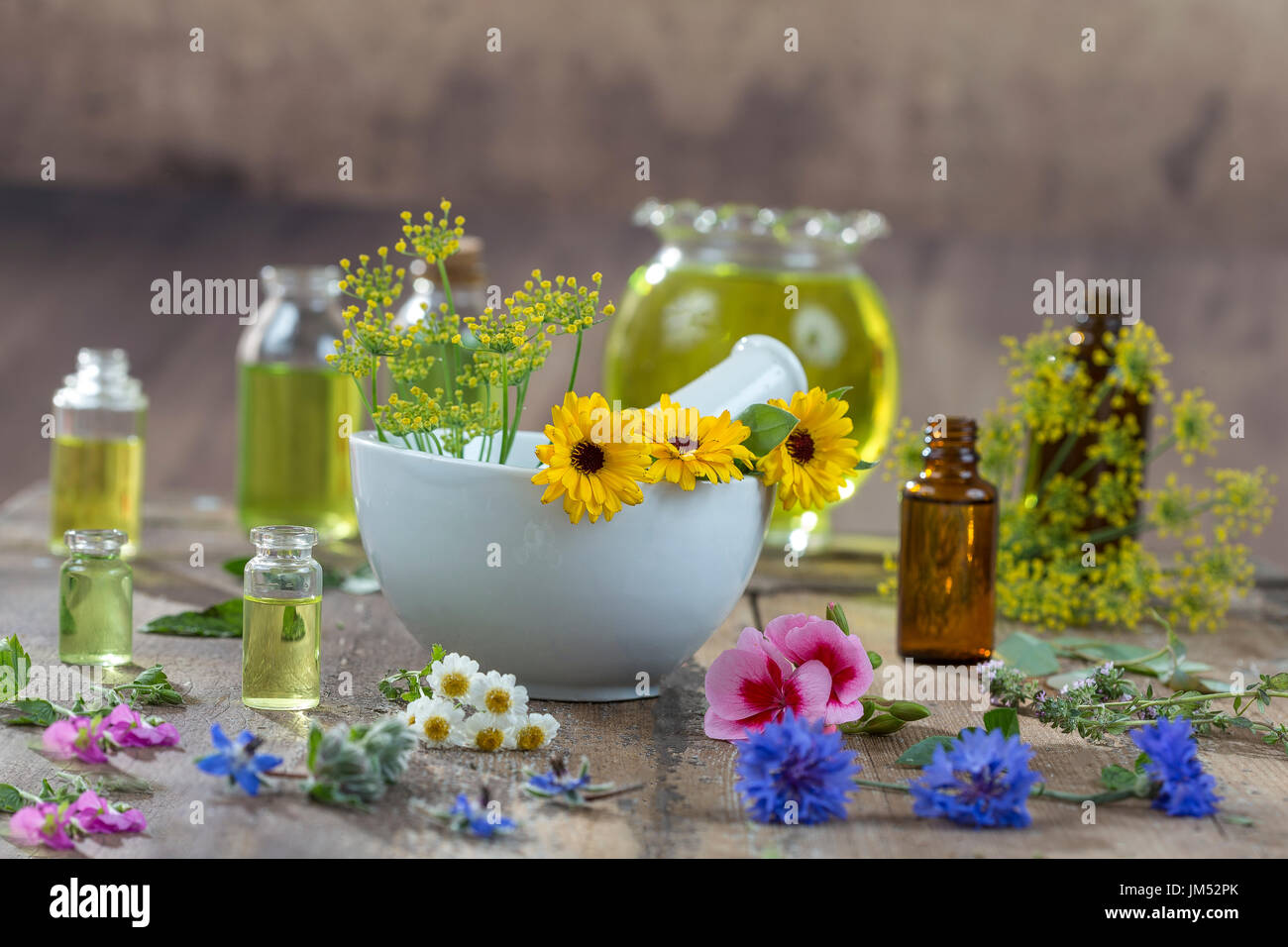 Oli essenziali per un trattamento di aromaterapia con erbe fresche in un mortaio sfondo bianco Foto Stock