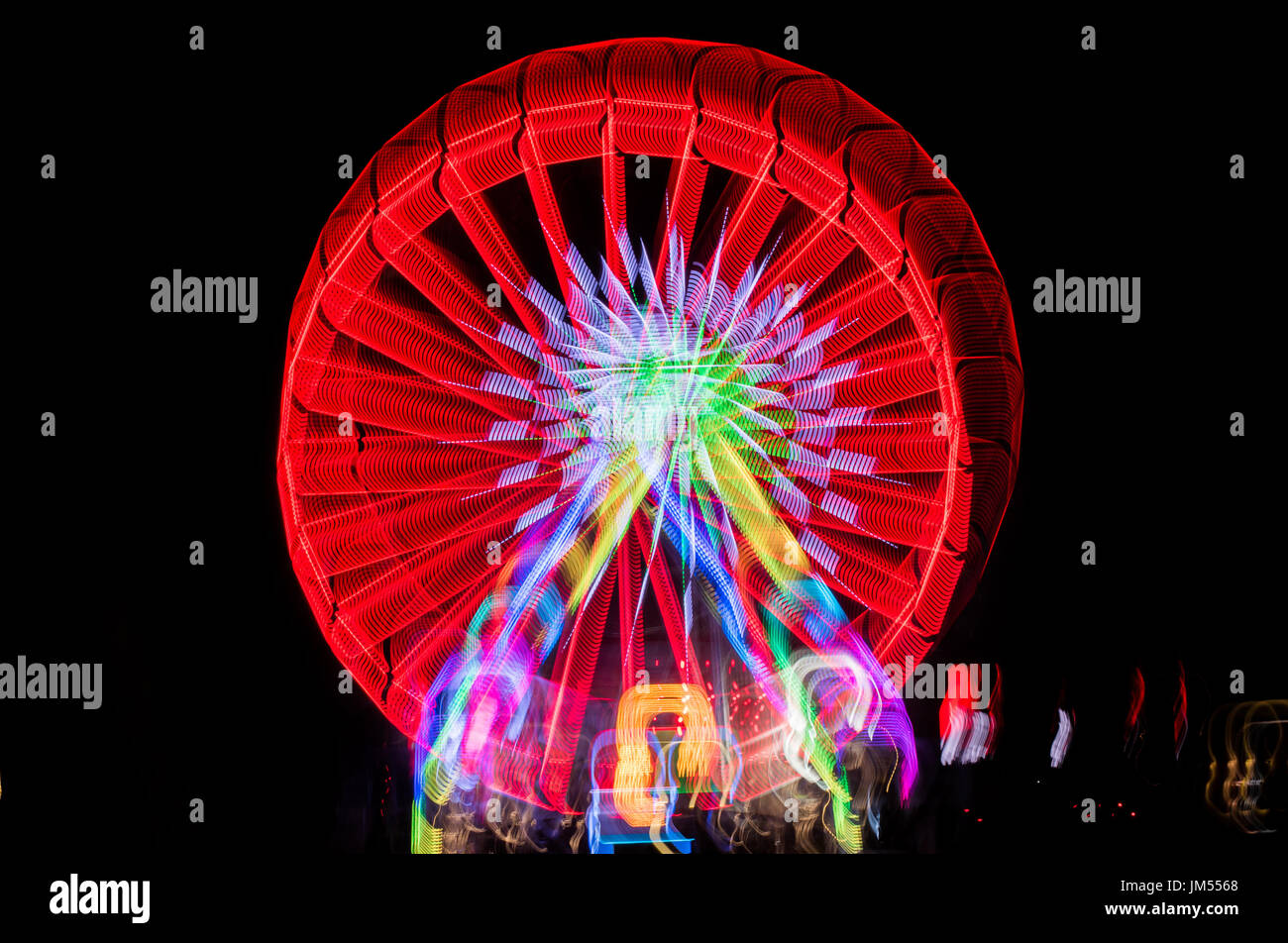Sfocata ruota gigante, ferris fotografati con una lunga esposizione tecnica di notte. Sfocatura del movimento Foto Stock