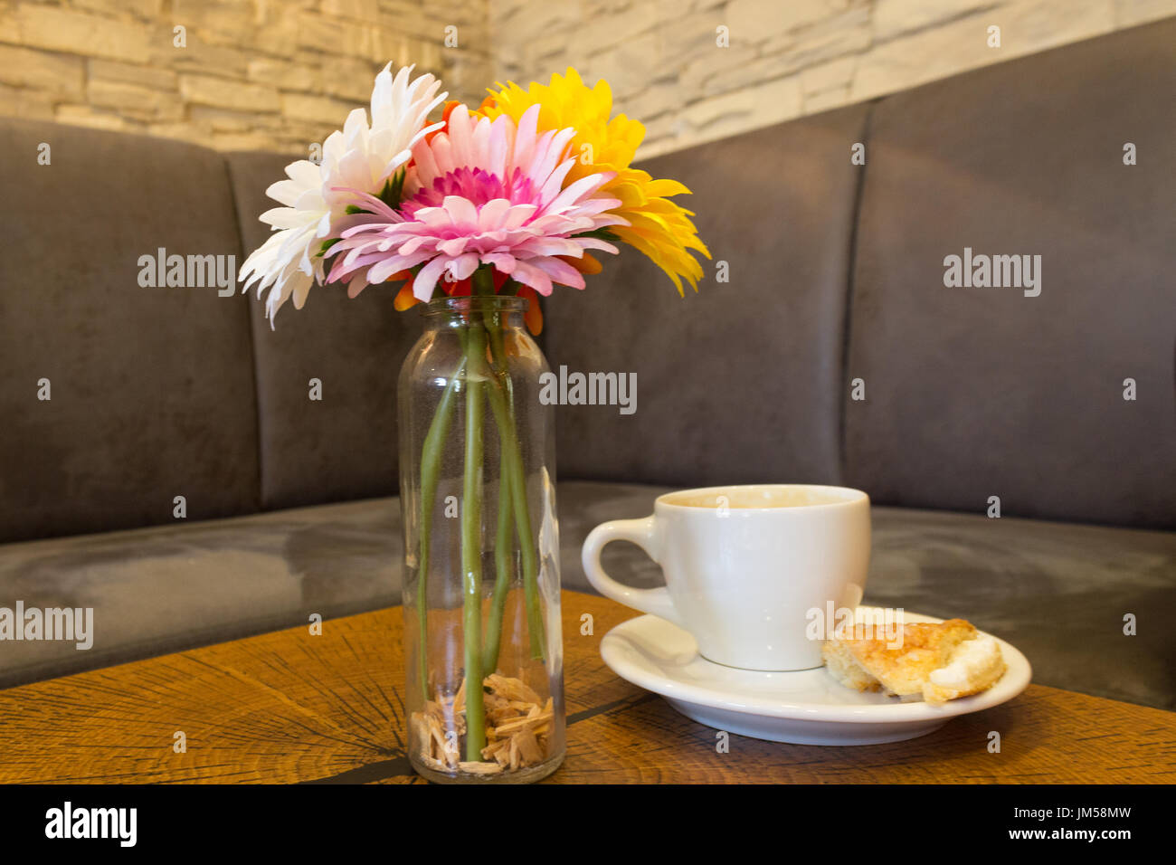 Gerbera in un vaso di vetro su un rustico di blocco di legno Foto Stock