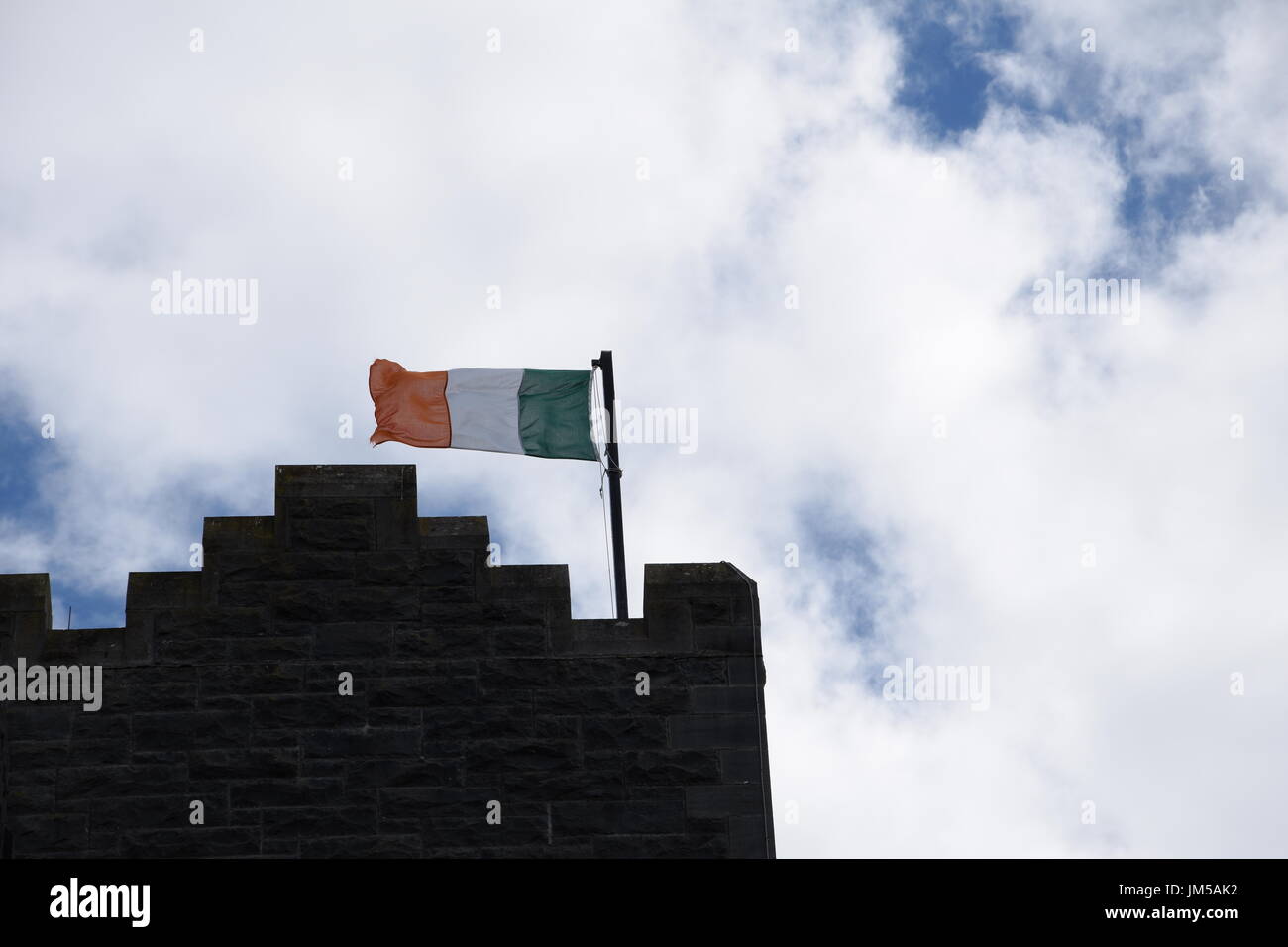 Bandiera irlandese battenti sul pennone a Ashford Castle tower Foto Stock