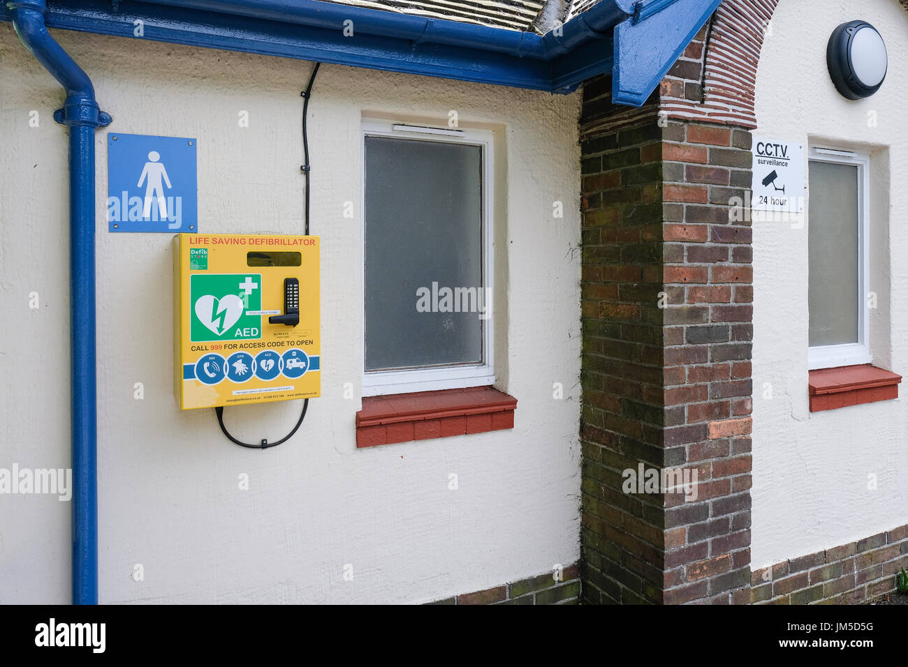 Defibrillatore montato su una parete di un pubblico maschile connvenience wc in Harrogate, North Yorkshire, Inghilterra, Regno Unito. Foto Stock
