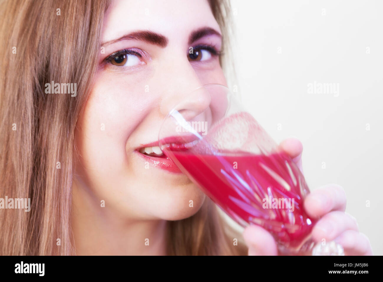 Una giovane ragazza bere un rosso succo beete Foto Stock