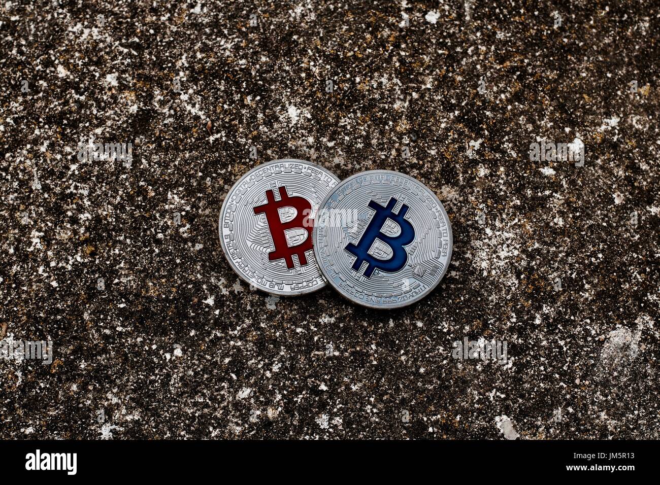 Valuta digitale argento fisico bitcoin monete sulla scena scura. Il rosso e il blu del concetto. Foto Stock