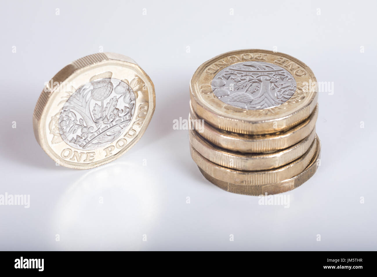 Dettaglio della nuova British pound coin con un elevato angolo di visione su una pila e una singola moneta in piedi sul bordo a fianco mostra l'incisione Foto Stock