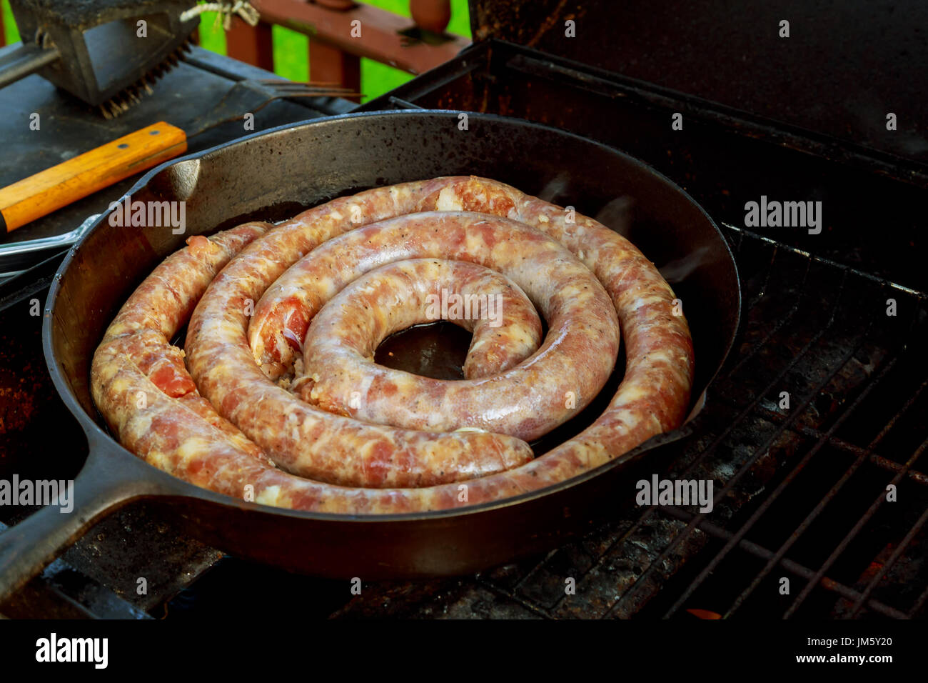 Display per vendere il barbecue con fiery salsicce alla griglia da una luce al neon di notte street market alimentare, immagine sfocata dal fumo di notte sul mercato locale Foto Stock