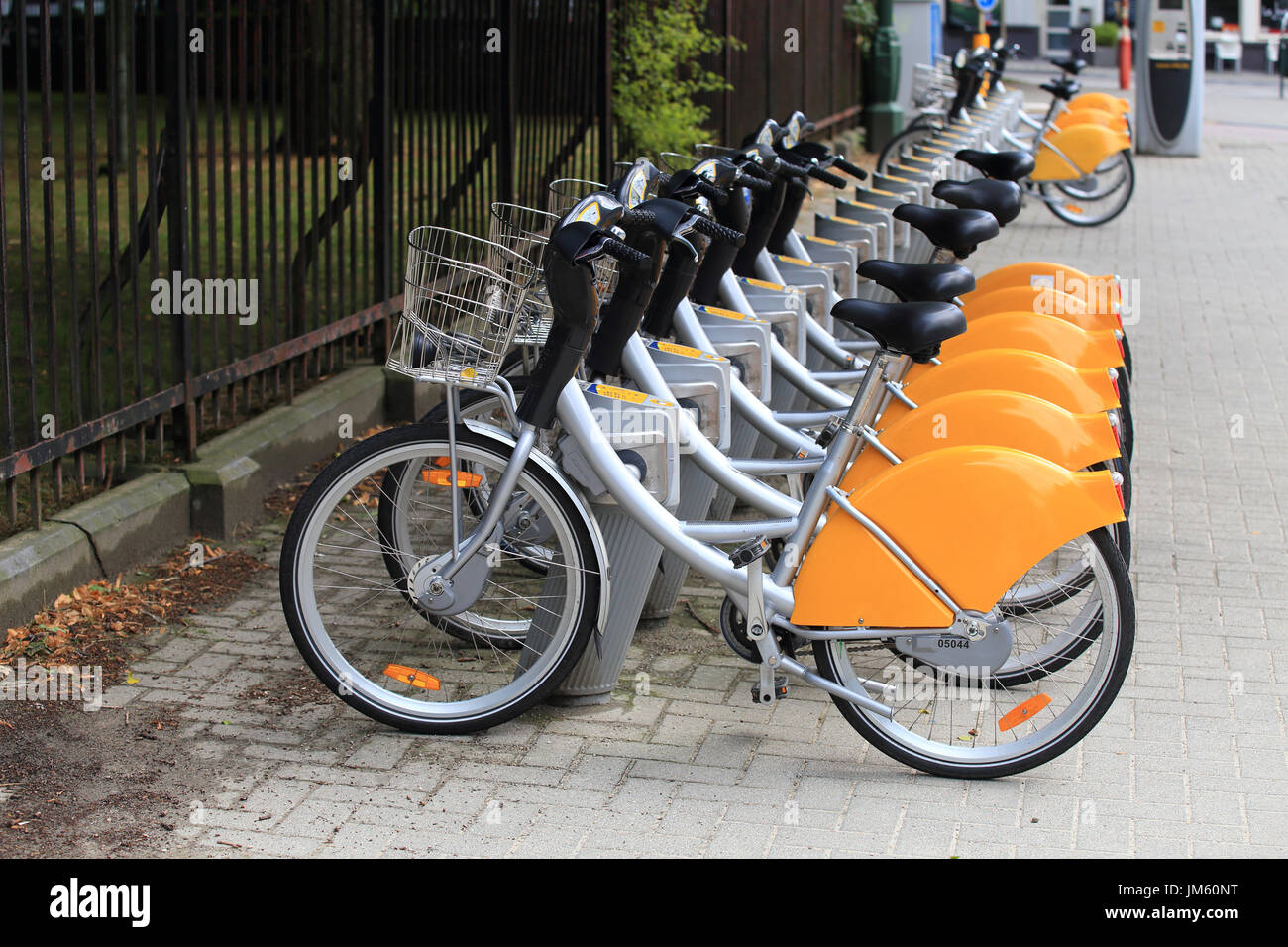 Noleggio biciclette in piedi in fila su strada. Noleggio biciclette per il parcheggio in città europea. Foto Stock