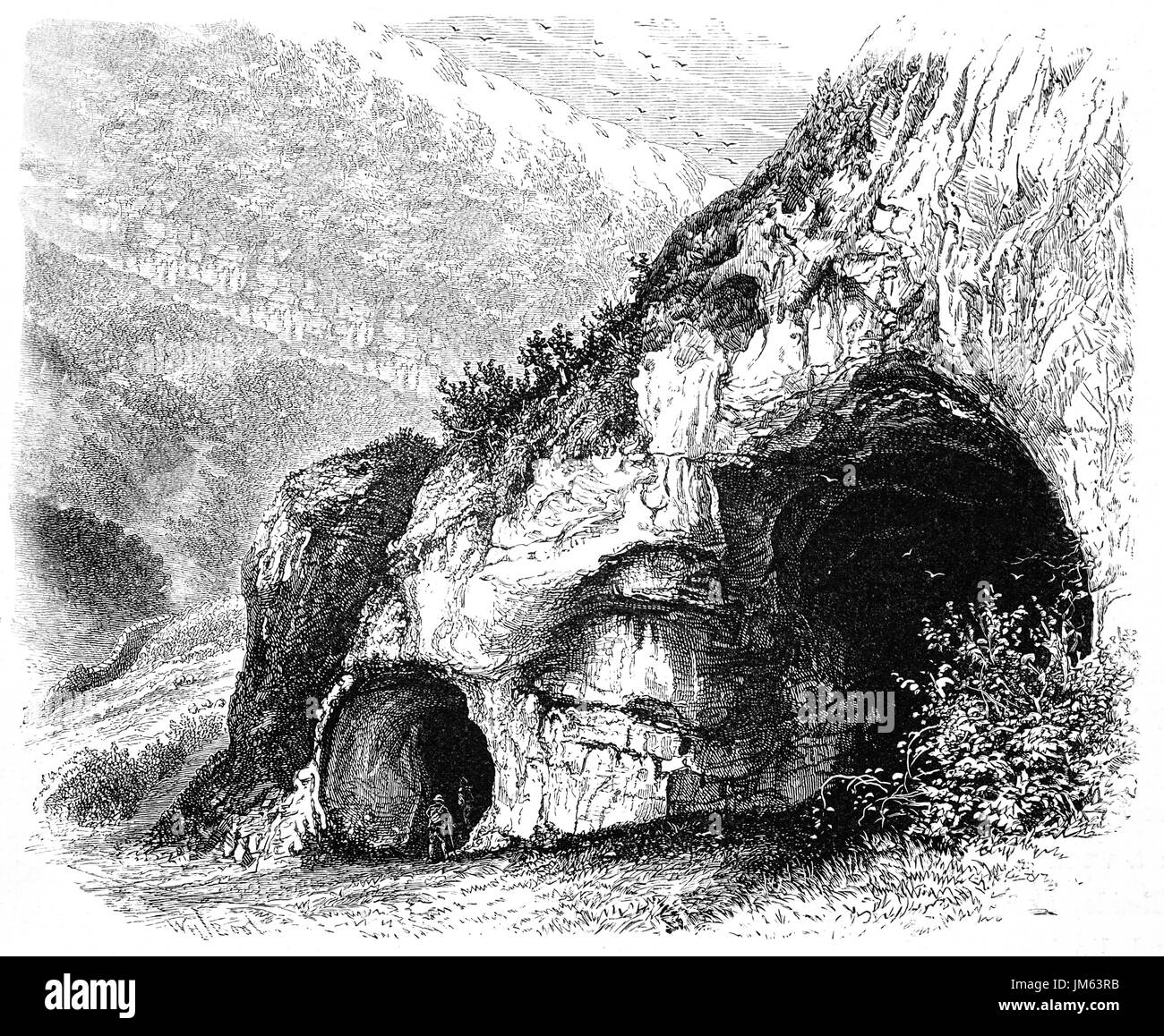 1870: Walkers esplorare uno dei fori di Colomba in Dovedale, una valle del Peak District, Derbyshire, Inghilterra Foto Stock