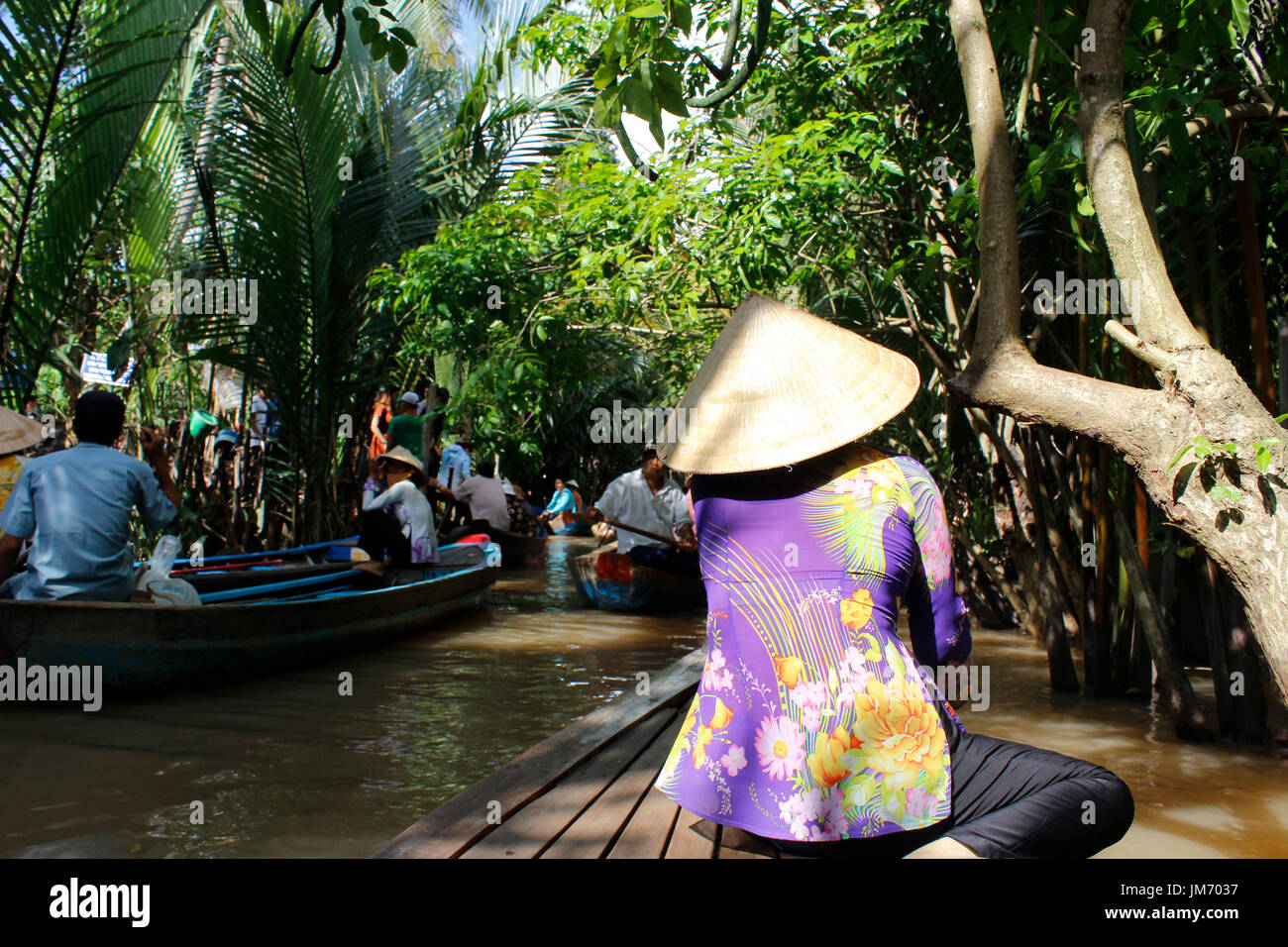 Donna vietnamita canottaggio un sampan (imbarcazione in legno) nel fiume Mekong, Ho Chi Minh Foto Stock