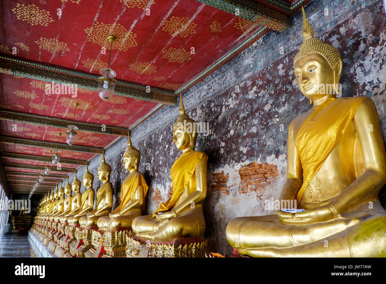 Udienza statue di Buddha nel corridoio esterno di Wat Suthat Thepwararam, un tempio buddista a Bangkok, in Thailandia. Foto Stock