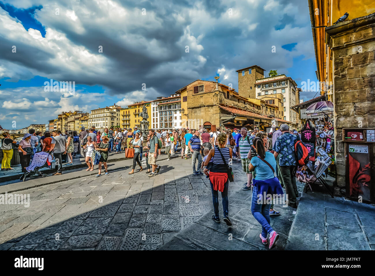Il medievale Ponte Vecchio a Firenze Italia con la folla di turisti shopping come una tempesta si avvicina al pomeriggio Foto Stock