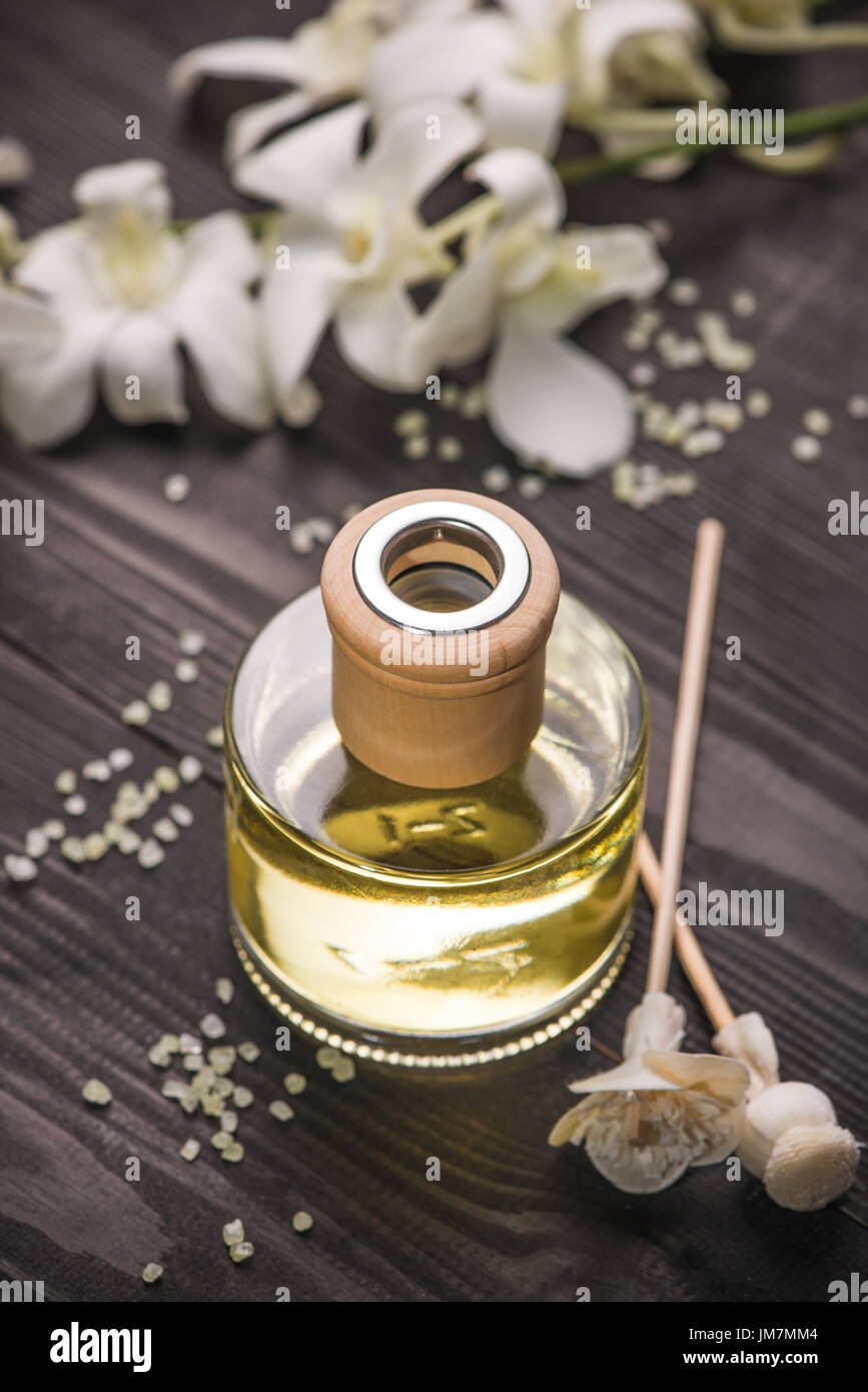 Spa decorazione. Bottiglia di olio essenziale e fiori di orchidea. Foto Stock