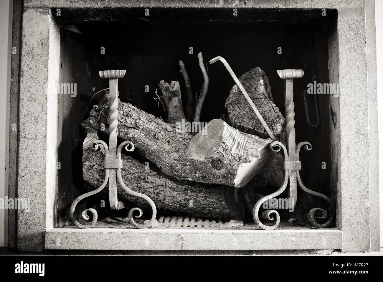 In vecchio stile in bianco e nero home decor interno camino a secco con tronchetti di legno e ferro andiron, fuoco Foto Stock