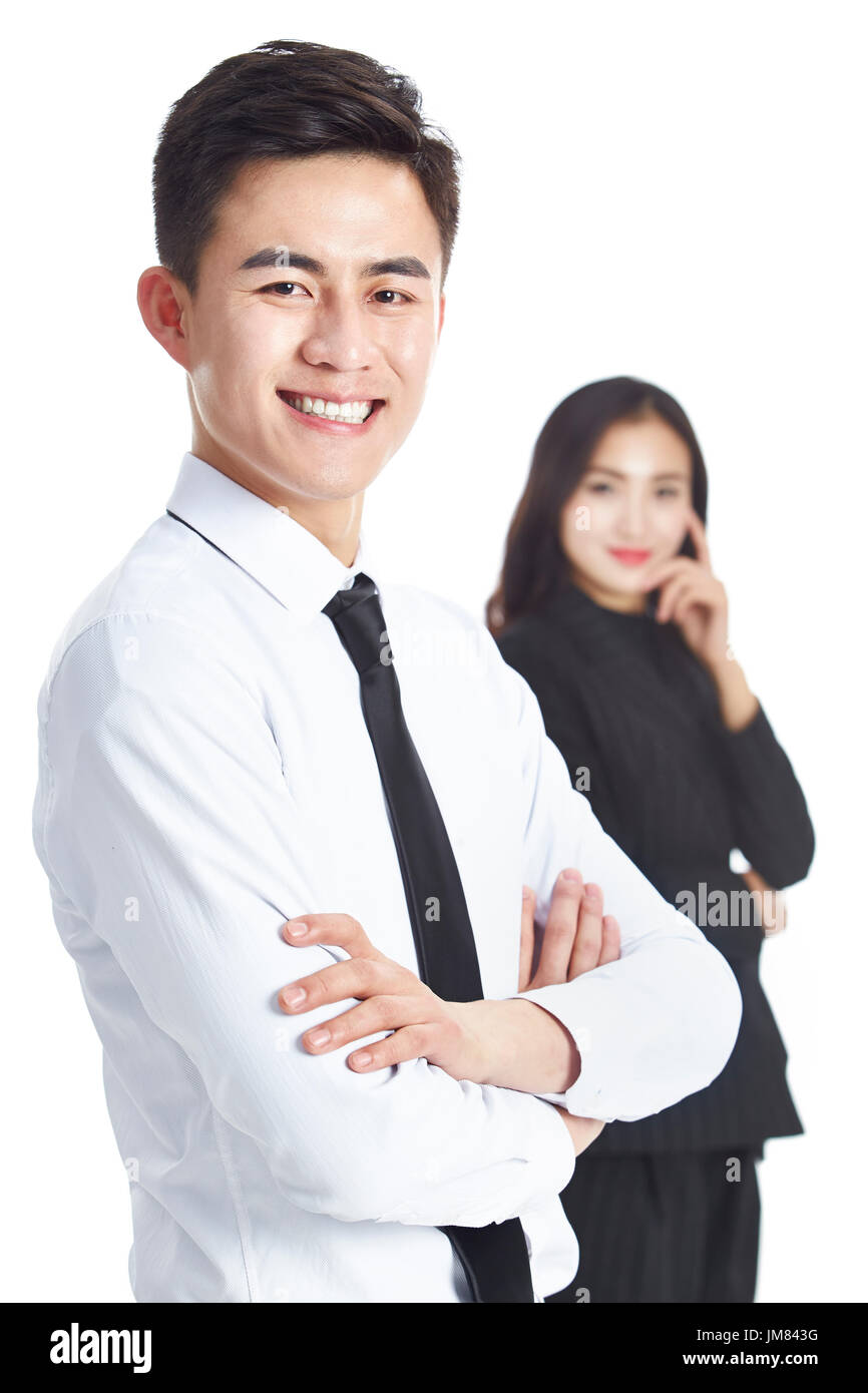 Ritratto di giovane imprenditore asiatico con il collega di sesso femminile in piedi in background, studio shot, isolato su bianco. Foto Stock