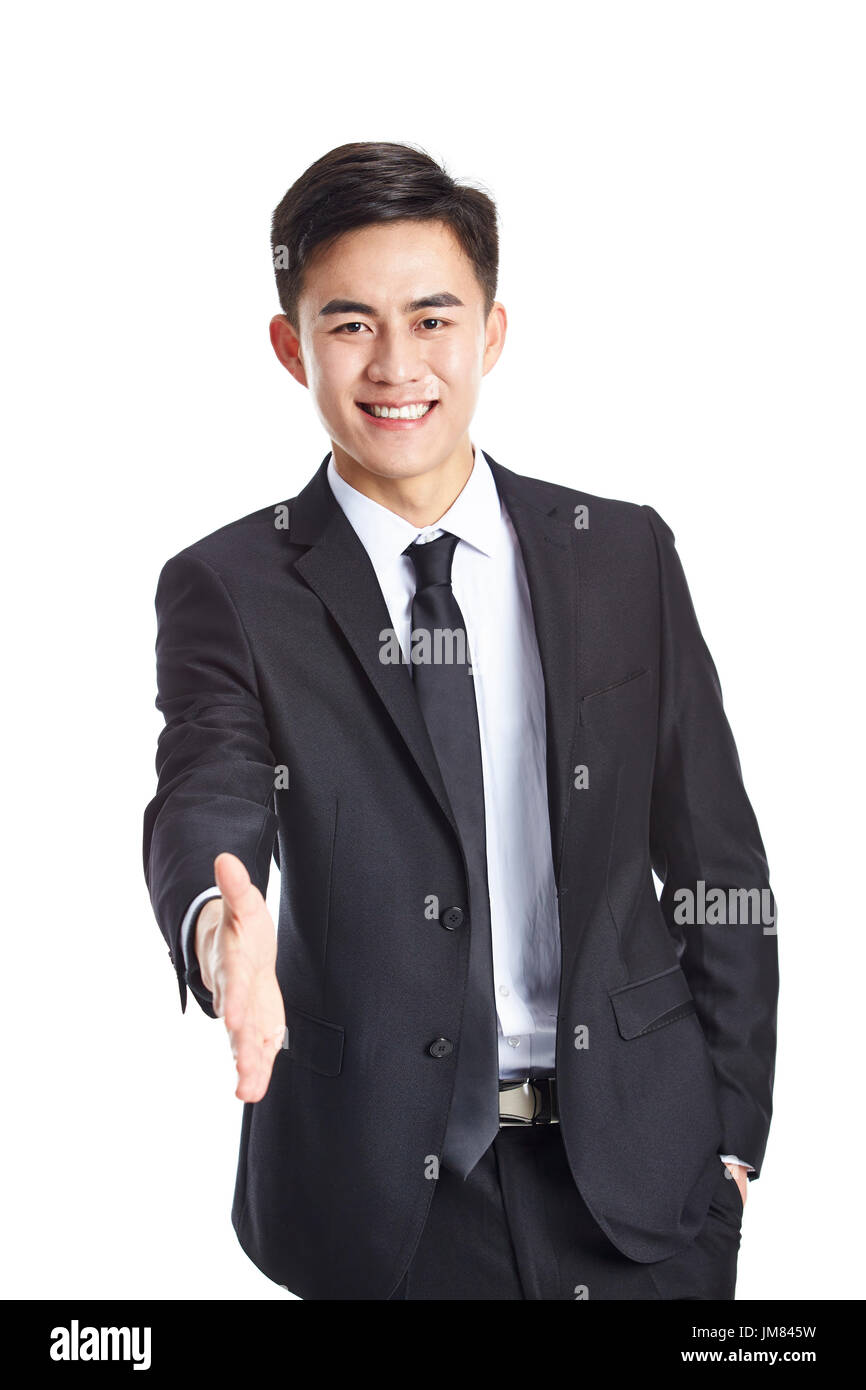Giovane imprenditore asiatici in abbigliamento formale di raggiungere fuori per una stretta di mano, felice e sorridente, studio shot, isolato su bianco backround. Foto Stock