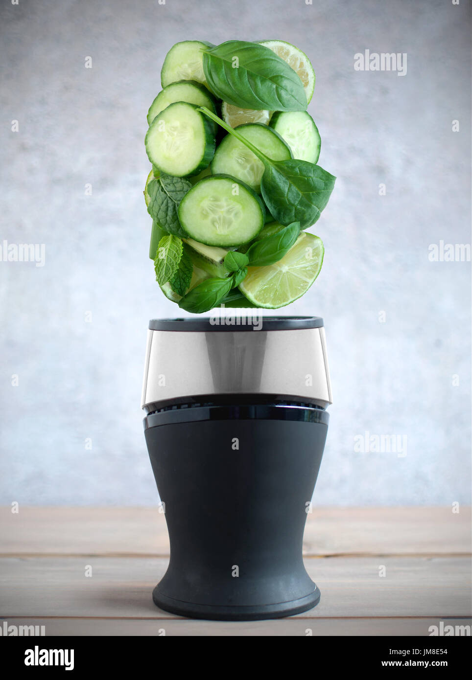 Freschi frutti di verde e di ingredienti vegetali passando al di sopra di un frullatore Foto Stock