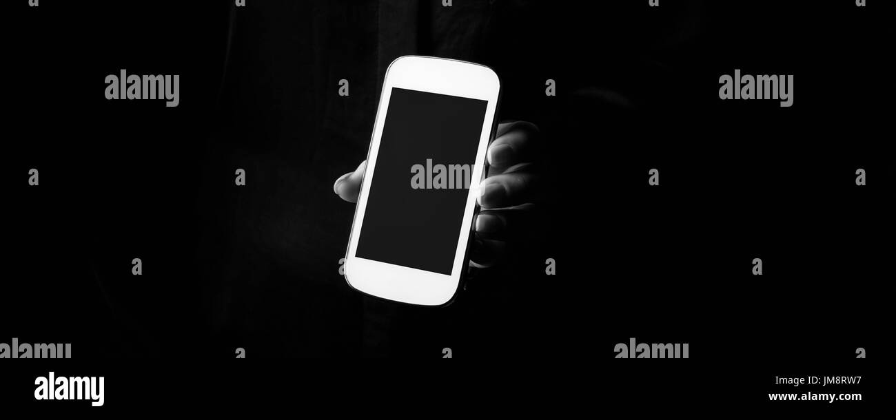 Black Mania. femmina isolato a mano su nero che mostra uno smartphone Foto Stock