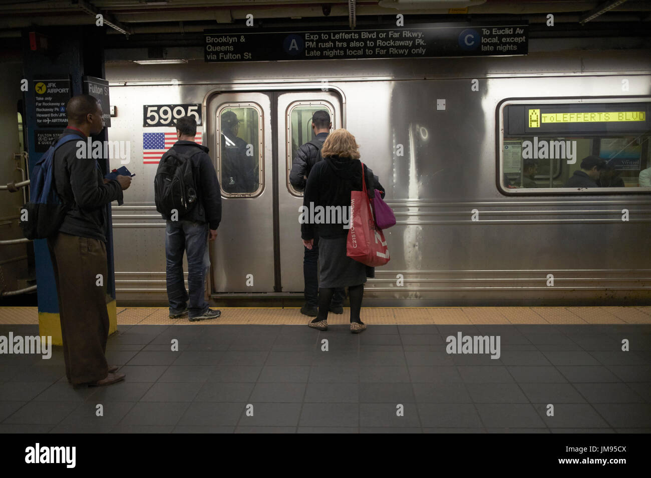 Persone in attesa di salire a bordo del treno in arrivo a new york alla metropolitana di New York City STATI UNITI D'AMERICA Foto Stock