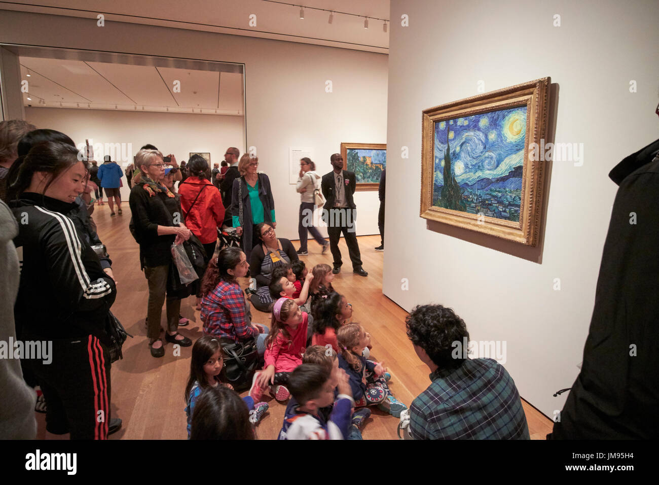 Gruppo scolastico on tour sedersi e guardare Vincent van goghs notte stellata Moma di New York City STATI UNITI D'AMERICA Foto Stock