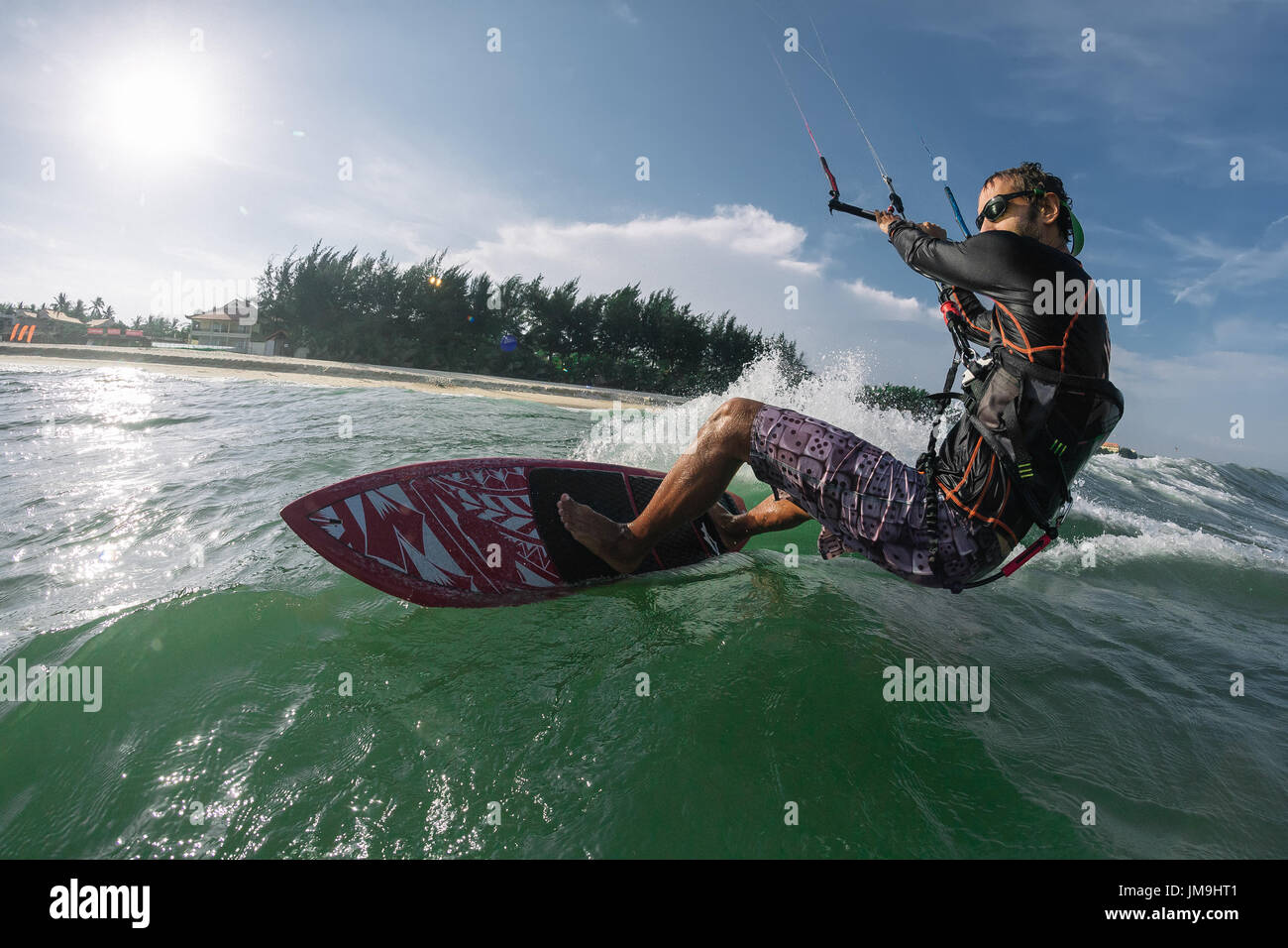 Un kite surfer Cavalca le onde Foto Stock