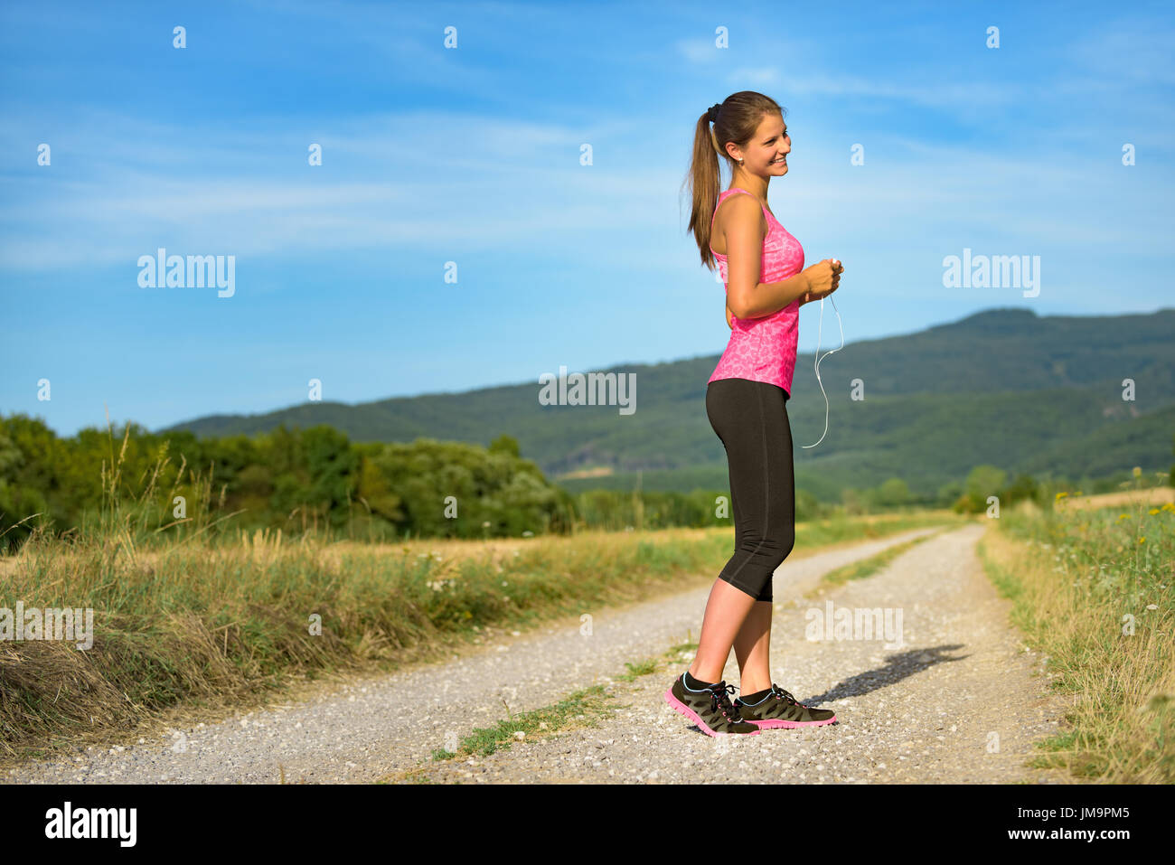 Attraente femminile partecipazione delle cuffie, pronto per il suo allenamento Foto Stock