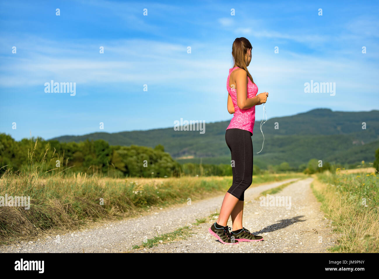 Attraente femminile partecipazione delle cuffie, pronto per il suo allenamento Foto Stock