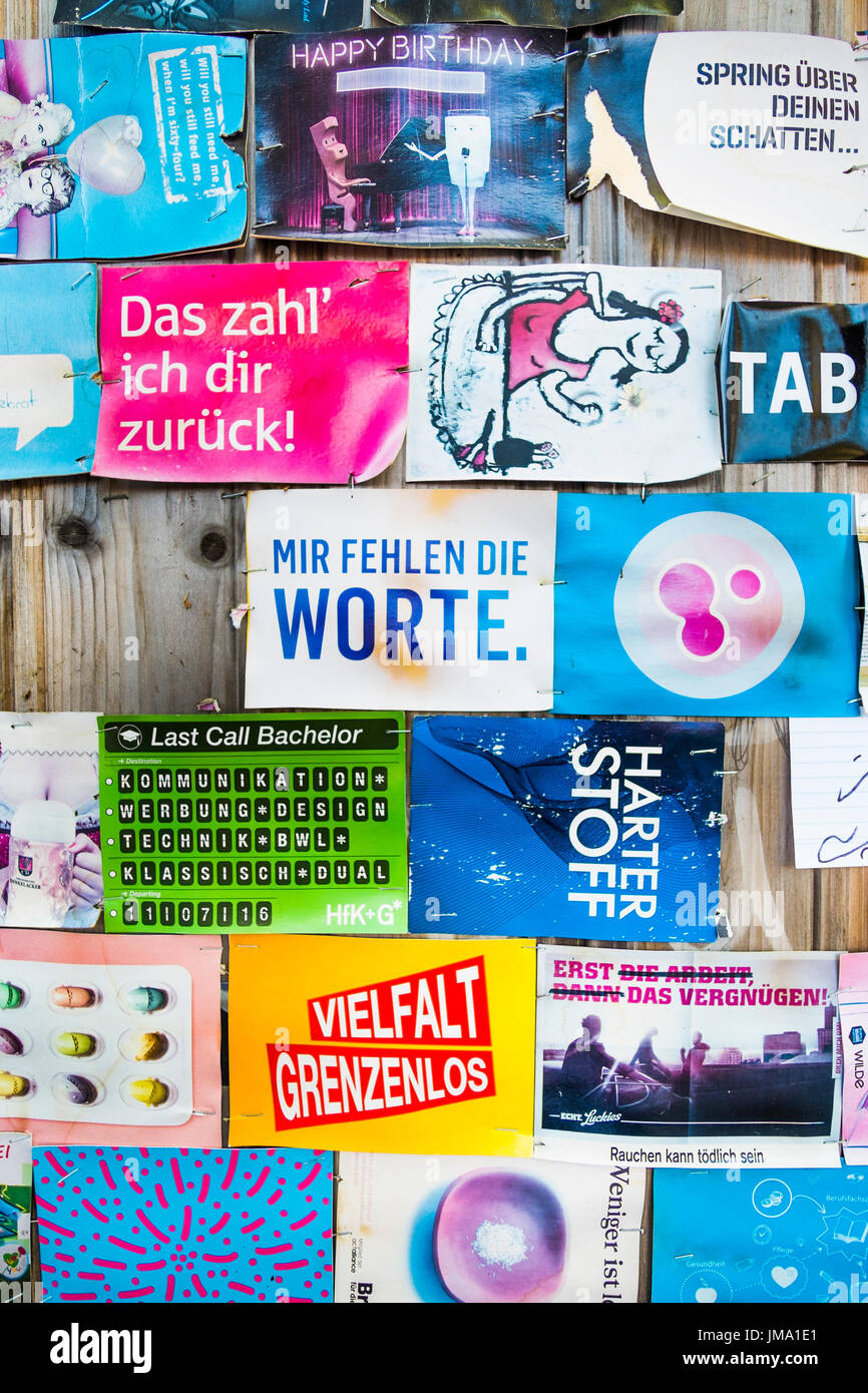 Weathered pubblicità gratuita cartoline di solito disponibili in luoghi pubblici imperniata ad una parete in legno, Stoccarda, BADEN-WUERTTEMBERG, Germania Foto Stock