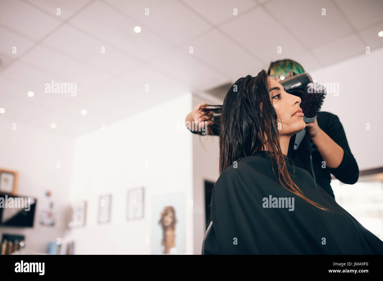 Femmina hair stylist usando la velocità del ventilatore e la spazzola per  capelli secchi. La donna in un sofisticato salone di bellezza di ottenere  un taglio di capelli Foto stock - Alamy