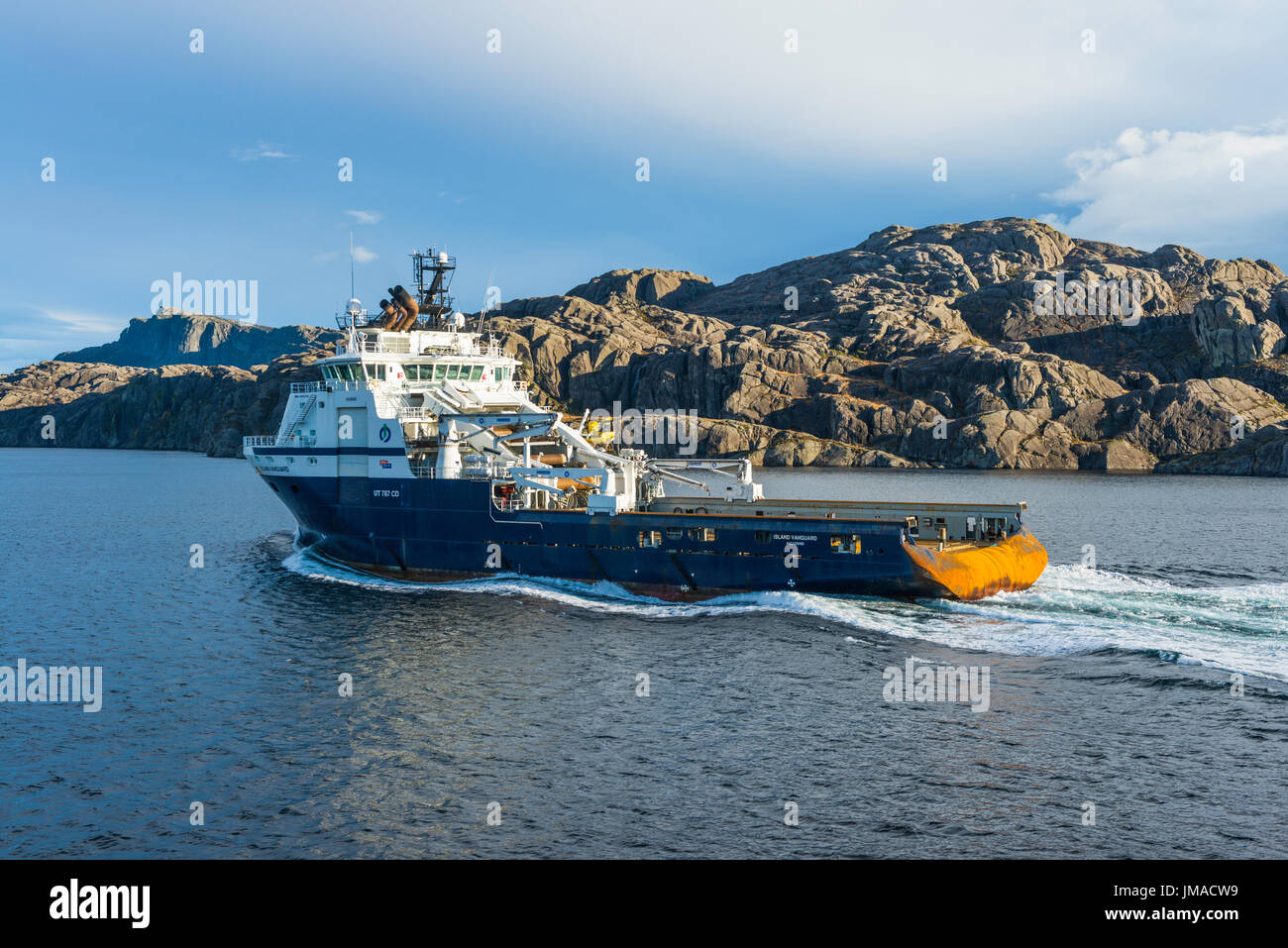Recipiente di alimentazione "Isola Vanguard' vapori passato norvegese paesaggio costiero, a nord di Bergen, visto da un Hurtigruten Coastal Express la nave di crociera. Foto Stock
