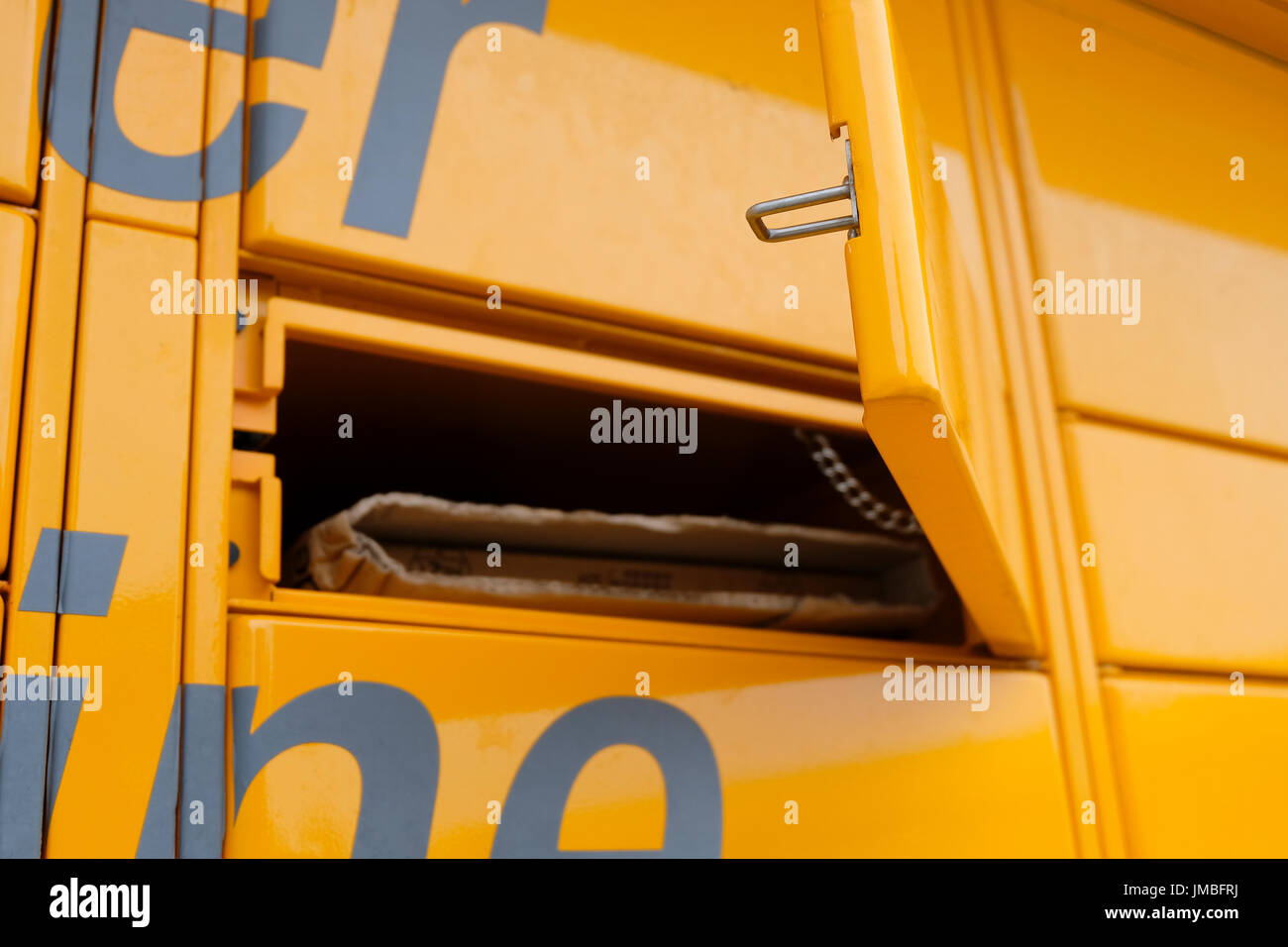 Porta di colore giallo brillante Amazon Locker chiamato Binky aperto dopo l'immissione del codice di raccolta che consenta di accedere al pacco Foto Stock