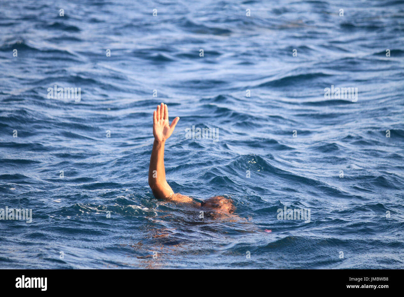 L'uomo che annega nel mare, che si estende per un uomo che annega nel mare, si estende una mano Foto Stock