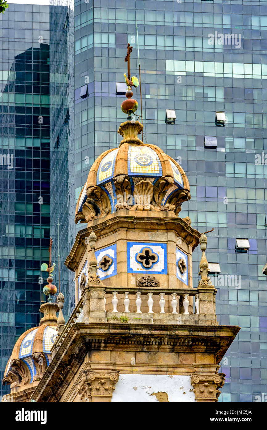 Vecchia chiesa nel centro di Rio de Janeiro città con nuovo e moderno in vetro nero edificio in background creando il contrasto tra il nuovo e il Foto Stock
