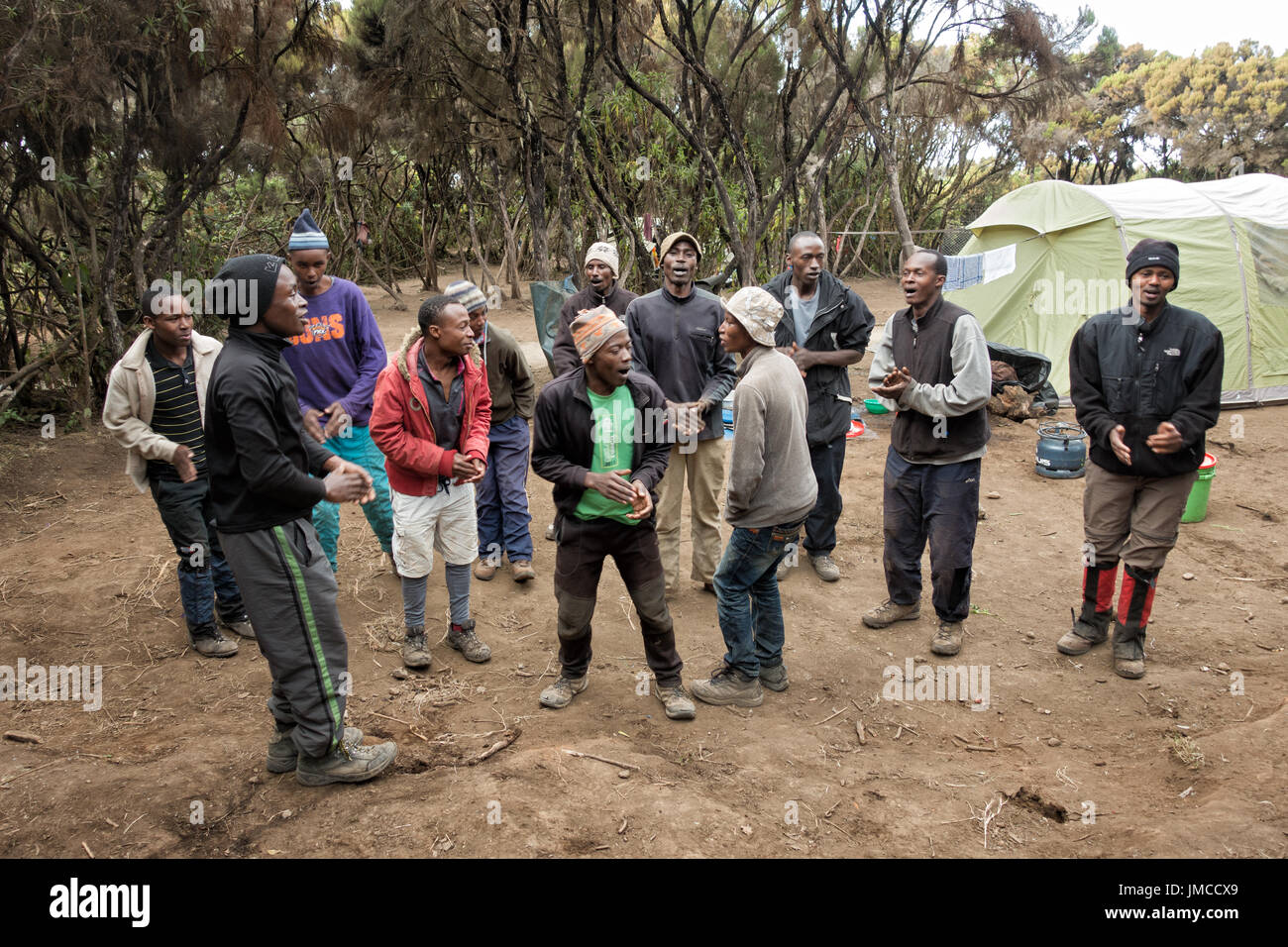 Facchini cantare il Kilimanjaro canzone al Mweka Camp l ultimo giorno di trek, Parco Nazionale del Kilimanjaro, Tanzania Foto Stock