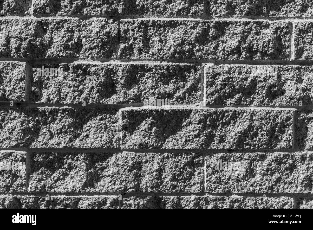 In bianco e nero la texture colpo di un ruvido muro di mattoni Foto Stock