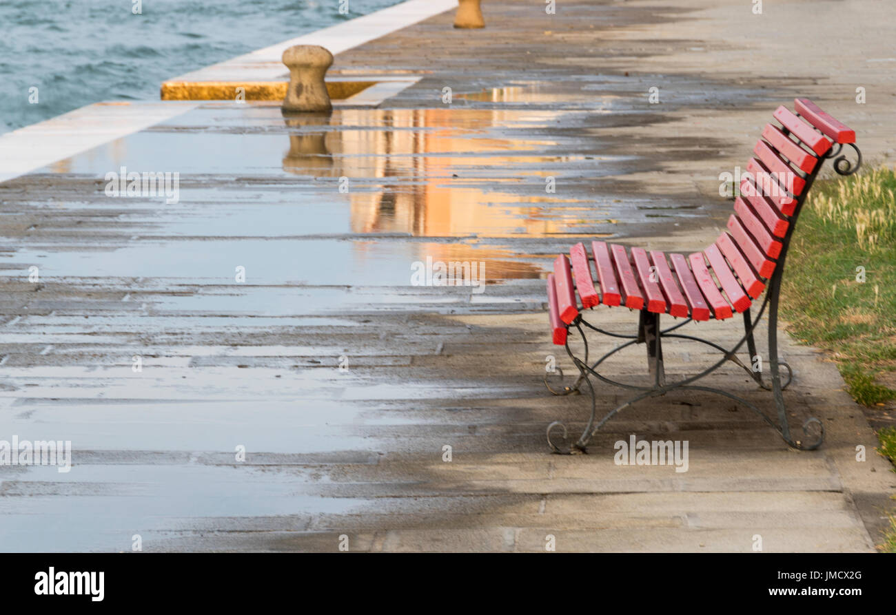 Pozzanghere sul marciapiede lungo il Canale della Giudecca in Venezia, Italia Foto Stock
